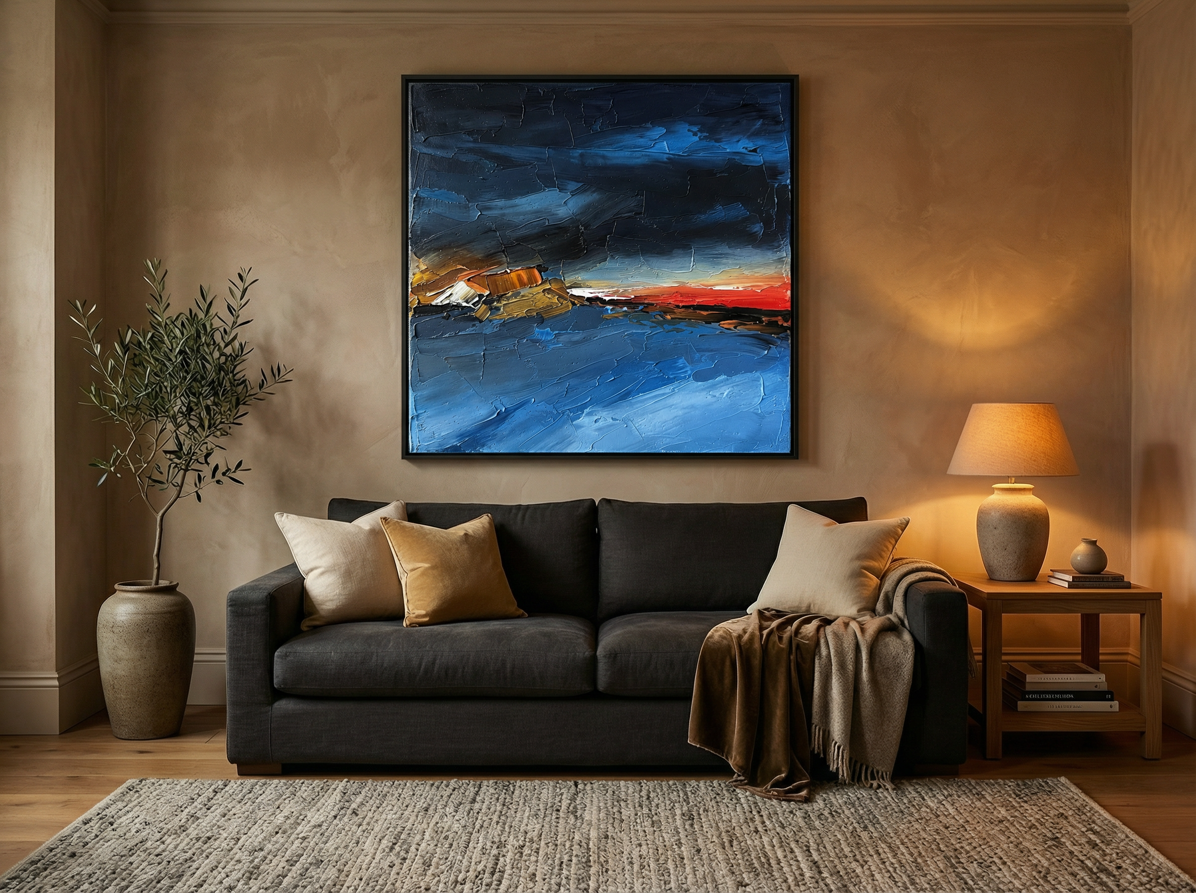Abstract painting in rich navy and gold tones displayed in a warm evening living room with ambient lighting and plush furnishings